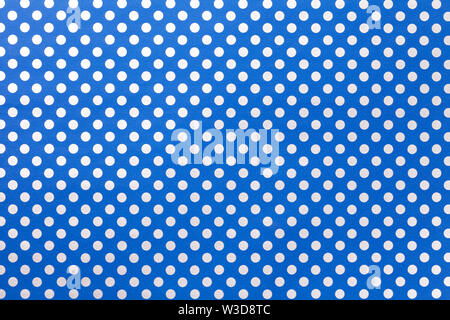Navy blue background from wrapping paper with a pattern of silver polka dot closeup. Texture of holiday white dotted paper surface. Backdrop of textil Stock Photo