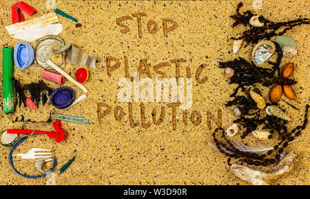 Real plastic pollution found on beach separated from natural beach seaweed and shells, stop plastic pollution text Stock Photo