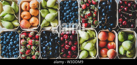 Summer fruit and berry assortment in wooden boxes, top view