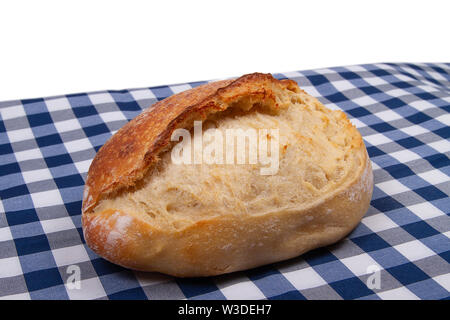 Artisan traditional french bread lies on table covered with rustic style checkered blue white tablecloth Stock Photo