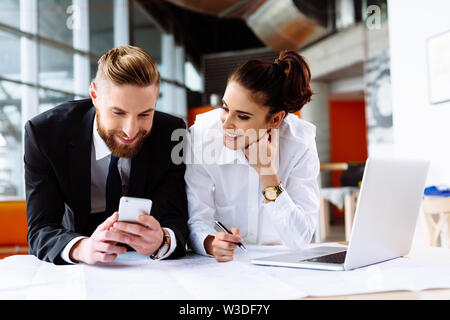Happy coworkers at office working over the desk with laptop Stock Photo