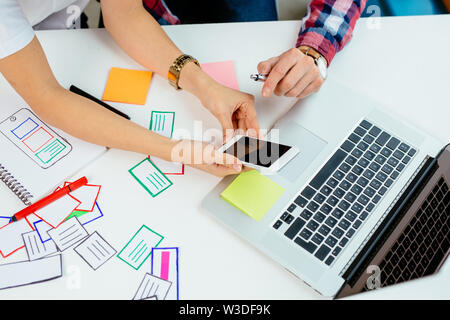Overhead picture of coworkers designing new smartphone app Stock Photo