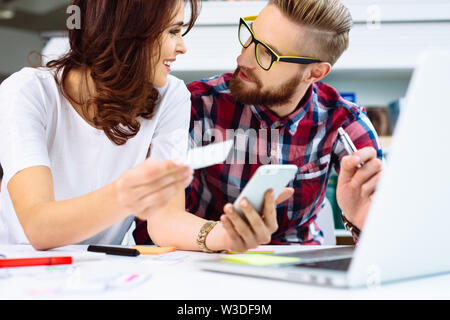 Couple of web designers working together at modern office, prototyping smartphone app Stock Photo