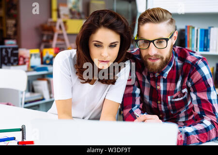 Designers working together on laptop in modern office Stock Photo