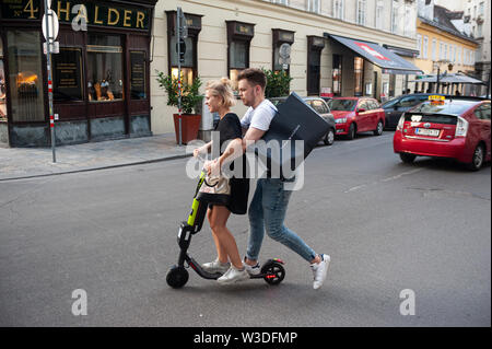 14.06.2019, Vienna, Austria, Europe - A young couple rides an electric scooter from the e-scooter provider Hive in central Vienna. Stock Photo
