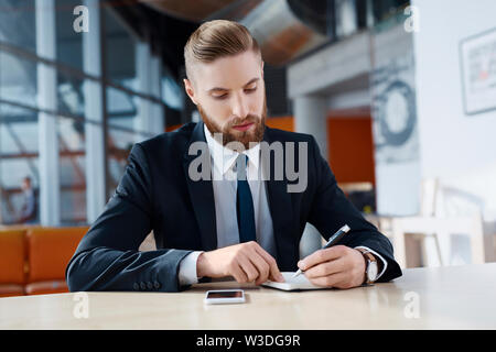 Busy hipster businessman taking notes Stock Photo