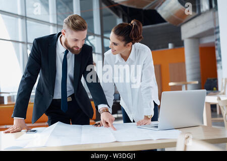 Young architects disccussing on construction plan Stock Photo