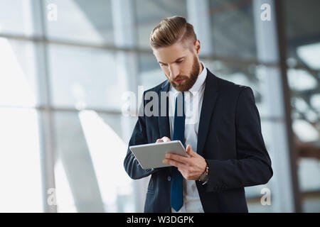 Modern hipster businessman working on digital tablet at office Stock Photo