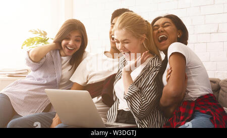Teen friends watching funny video on laptop Stock Photo