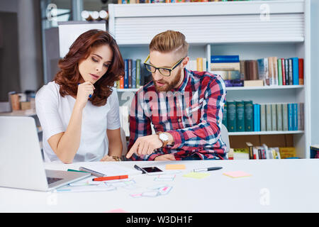 Training with design mentor. Two web designers discussing new responsive webdesign. Stock Photo