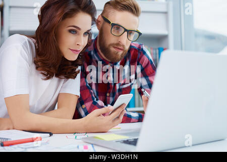 Busy web designers working together on new project Stock Photo
