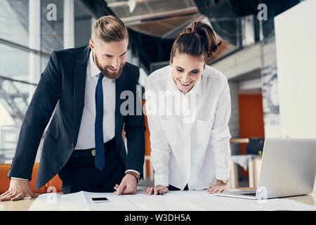 Two architects discussing design blueprint at modern office Stock Photo
