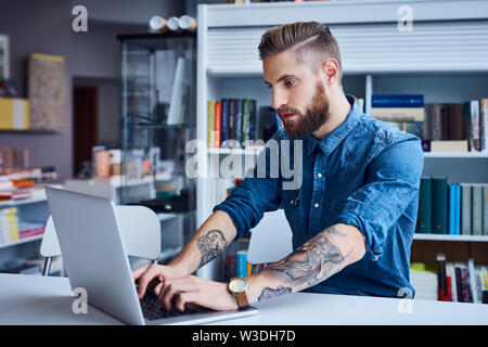 Hipster, designer working on laptop in office Stock Photo