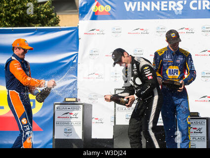 (190715) -- TORONTO, July 15, 2019 (Xinhua) -- Team Penske's driver Simon Pagenaud (C) of France and Chip Ganassi Racing's driver Scott Dixon (L) of New Zealand spray champagne to each other during the awarding ceremony of the 2019 Honda Indy Toronto of the NTT IndyCar Series at Exhibition Place in Toronto, Canada, July 14, 2019. Team Penske's driver Simon Pagenaud of France claimed the title with a time of 1:30:16.4388. (Xinhua/Zou Zheng) Stock Photo
