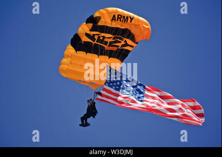 A U.S. Army parachutist with the Golden Knights parachute team approaches his landing July 13, 2019, at the “Mission Over Malmstrom” open house event on Malmstrom Air Force Base, Mont.  The demonstration and competition team consists of 24 members who perform at events across the country showcasing their abilities.  The two-day event, featured performances by aerial demonstration teams, flyovers, guided tours and static displays. (U.S. Air Force photo by Devin Doskey) Stock Photo