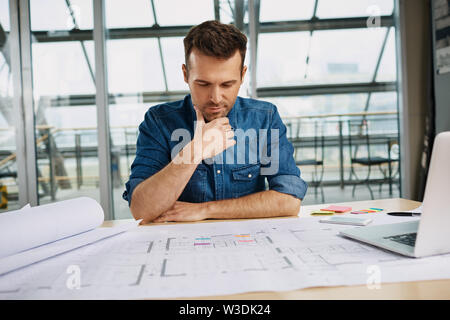 Thoughtful male architect working at office Stock Photo