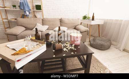 Chaos in room after party. Beer bottles, popcorn and pizza Stock Photo