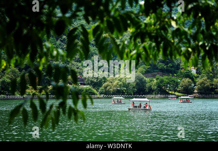 Xi'an, China's Shaanxi Province. 14th July, 2019. Tourists take boats on the Tianchi Lake of the Cuihua Mountain of the Qinling Mountains in Xi'an, northwest China's Shaanxi Province, July 14, 2019. Credit: Liu Xiao/Xinhua/Alamy Live News Stock Photo
