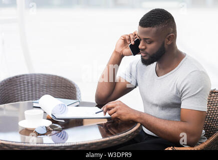 Concentrated african businessman checking his data in notepad Stock Photo