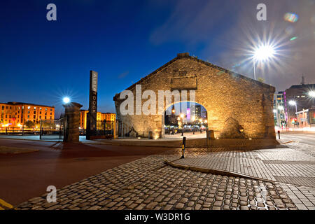 The granite stone gable and arch entrance to the Royal Albert Dock Liverpool Uk at dusk. Stock Photo