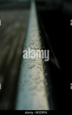 Water droplets sitting on stanless steel guardrail at dawn. Stock Photo