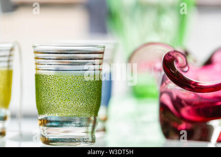 Colorful Antique Drinking Glassware on display on a shelf - glass cup or tumbler Stock Photo