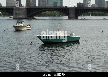 Two skiff type boat sailing with a bridge in the background Stock Photo