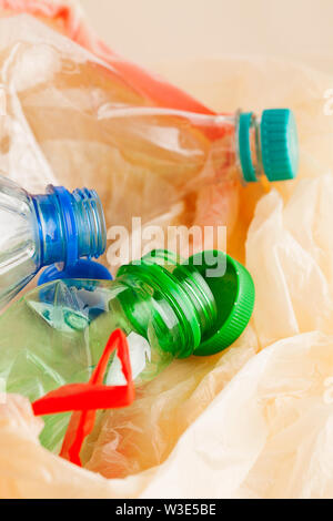 Used empty plastic water bottles crushed and crumpled in garbage bag for sorting (segregating) and recycling close-up.Environment pollution Stock Photo