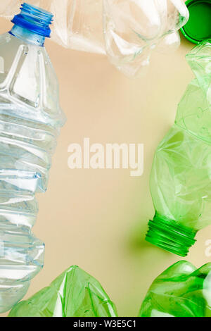 Used empty plastic water bottles crumpled for sorting (segregating) and recycling on coral pink background top view with copy space Stock Photo