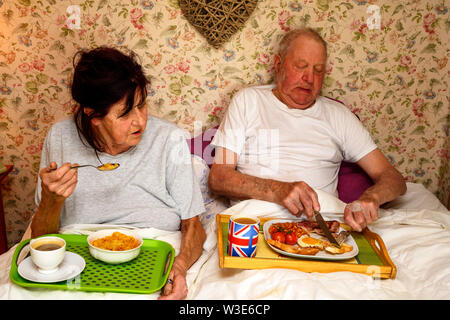 Couple eating breakfast in bed Stock Photo