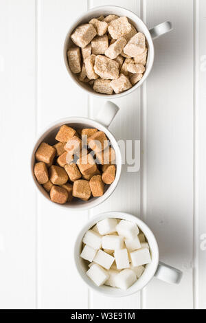 White and brown sugar cubes in coffee mug. Top view. Stock Photo