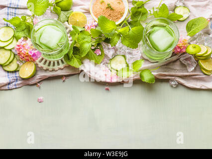 Green cucumber mojito drink making. Glasses with green summer refreshing drinks with ice cubes and ingredients. Green lemonade. Detox infused water. Stock Photo