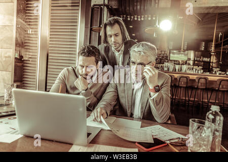 Serious grey-haired male being deep in thoughts Stock Photo