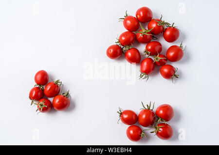 Small red ripe tomatoes pattern over white wooden background. Stock Photo