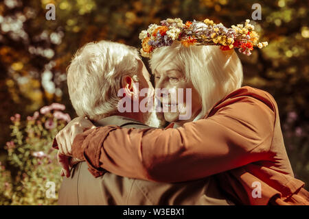 Thoughtful senior woman in arms of her husband. Stock Photo