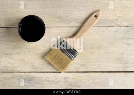 A brush lies next to a thermos with a cup on an old white vintage wooden board. Place for text or logo. Stock Photo