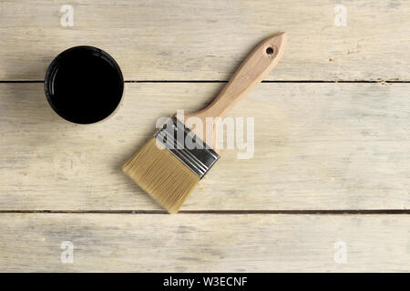 A brush lies next to a thermos with a cup on an old white vintage wooden board. Place for text or logo. Stock Photo