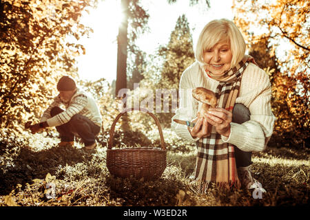 Happy woman holding a mushroom in front of her husband. Stock Photo