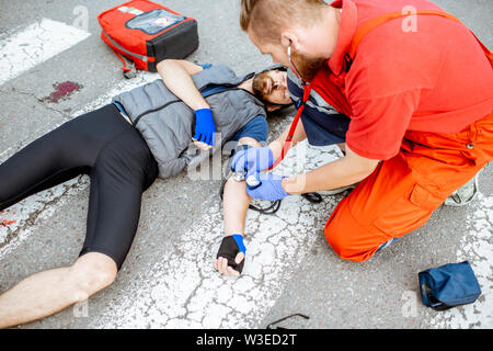 Cyclist lying on the road after an accident Stock Photo - Alamy
