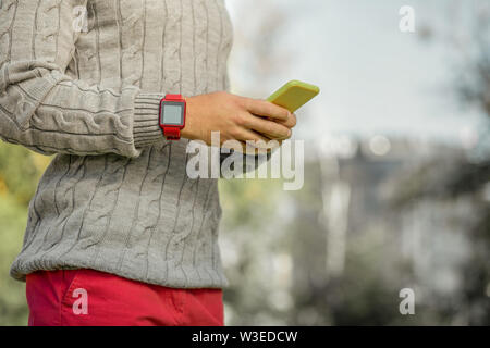 Busy man in bright red pants and grey sweater having electronic watch Stock Photo