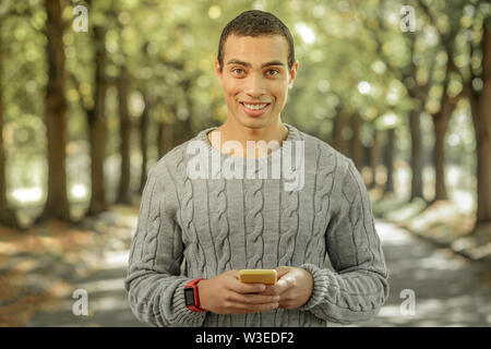 Cheerful young man spending sunny day outside Stock Photo