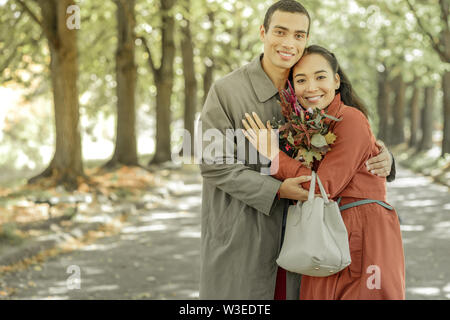 Sweet good-looking couple tightly hugging each other Stock Photo
