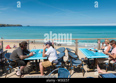 Holidaymakers sitting on the terrace of the Fistral Beach Bar and relaxing in the mid morning sunshine in Newquay in Cornwall. Stock Photo