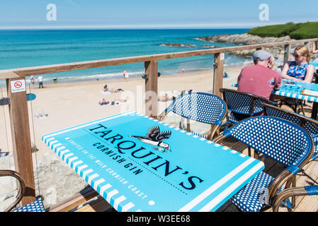 Tables advertising Tarquin’s Gin on the seating deck of the Fistral Beach Bar at Fistral in Newquay in Cornwall. Stock Photo