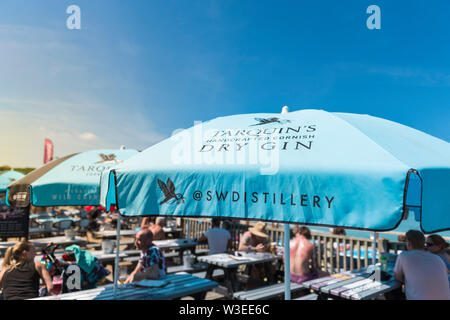Tarquin’s Gin sponsored umbrellas providing welcome shade on a very hot day over Fistral Beach Bar in Fistral in Newquay in Cornwall.