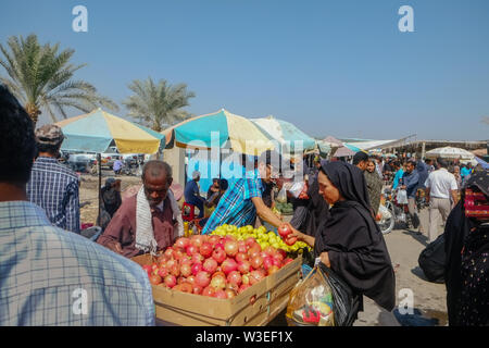Minab, Iran. October 27, 2016 : Street vendor selling fruit and local consumer buying and walking around the Minab Thursday market. Stock Photo