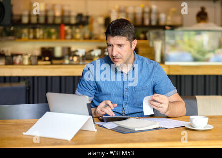 Mature business owner using digital tablet calculating profit of new business Stock Photo
