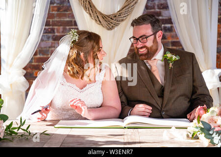 Bride and Groom laughing during signing of the register Stock Photo