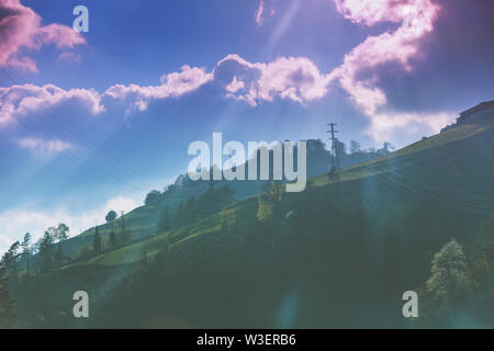 Mountain range overgrown with forest against the sky at sunrise Stock Photo