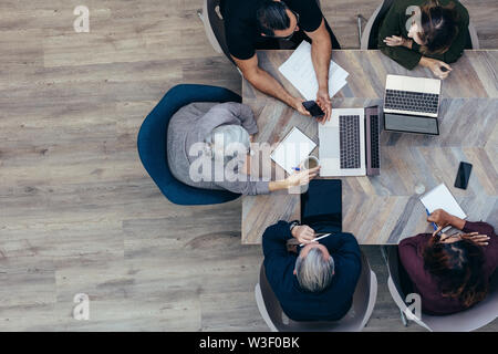 Top view od senior businesswoman discussing with her coworkers. Business team meeting in office. Stock Photo